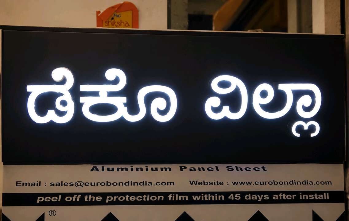 White acrylic Kannada lettering on an aluminium composite panel signboard